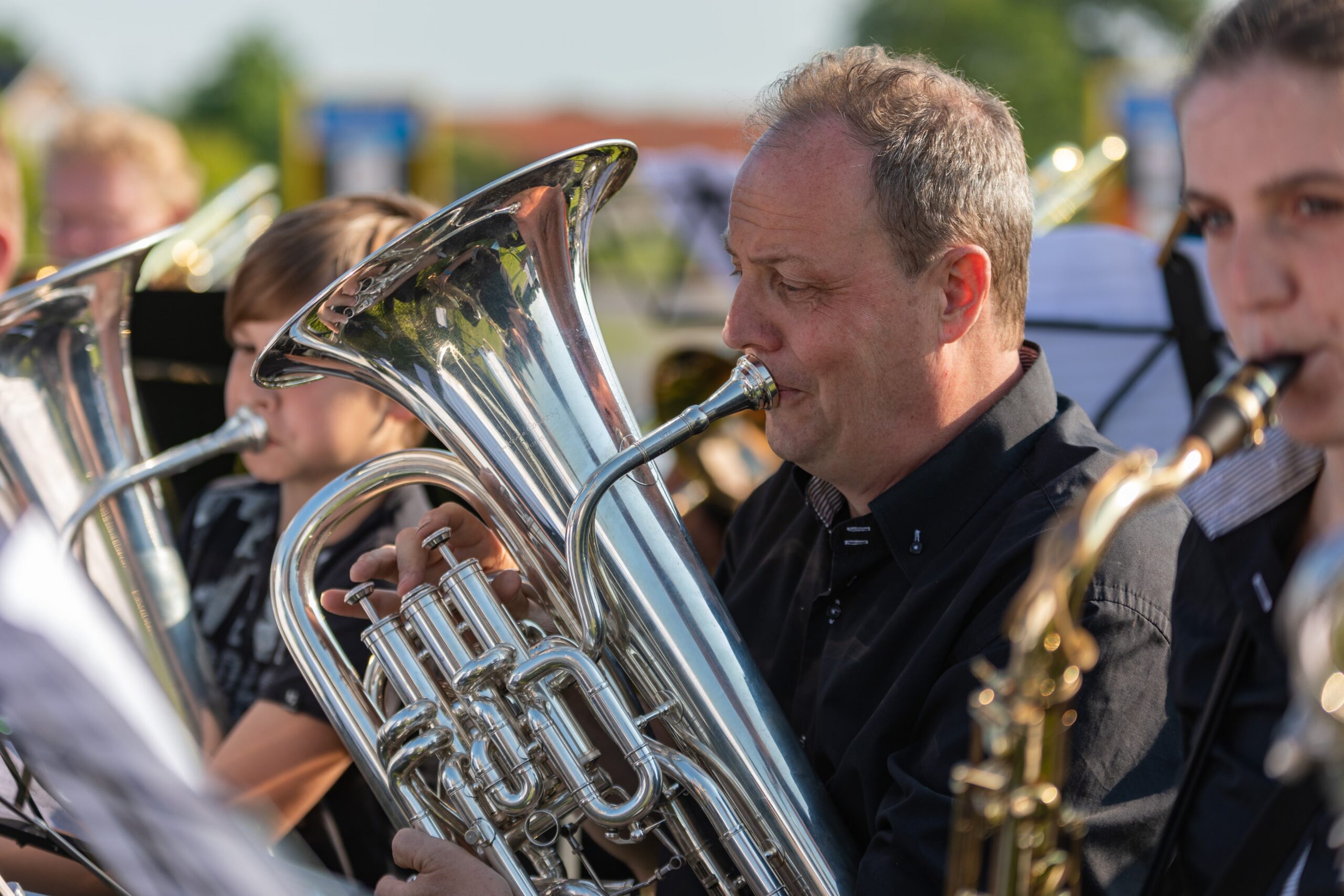Muzikant van Ons Genoegen bespeelt zijn koperinstrument tijdens een optreden in Terwolde