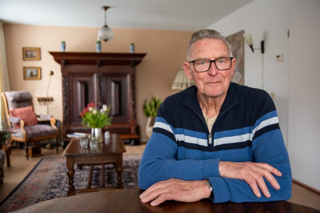 Gerrit Lubberts aan tafel in zijn woonkamer in Terwolde