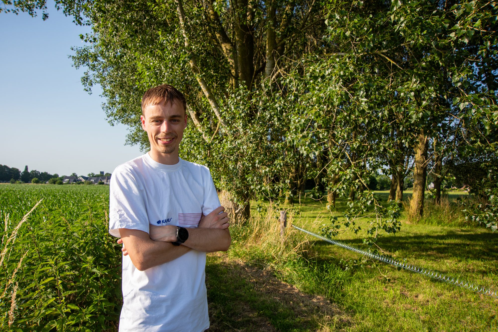 Lachende Chiel van Mourik langs een bomenrij bij een veld in Terwolde